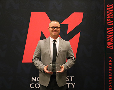 JJ Snodgrass holding award in front of Northeast Backdrop